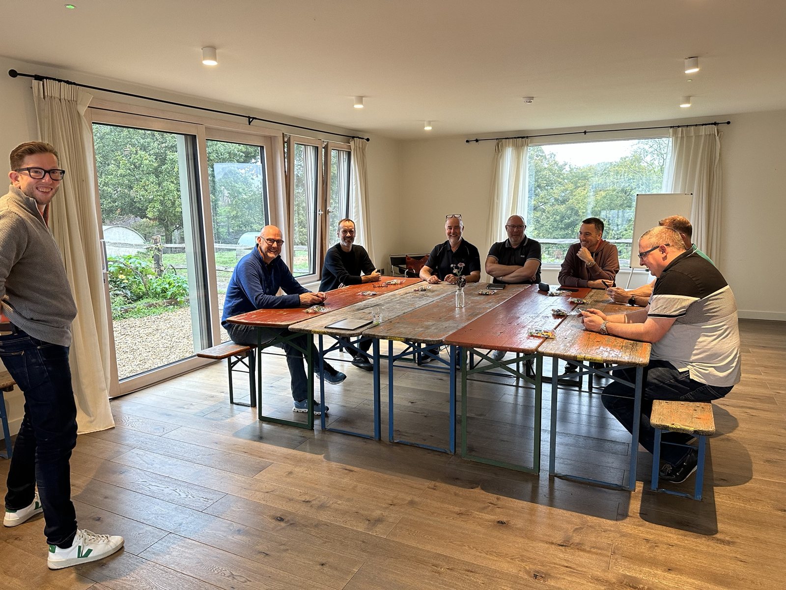 A peer group of business leaders gathered around a table building LEGO models