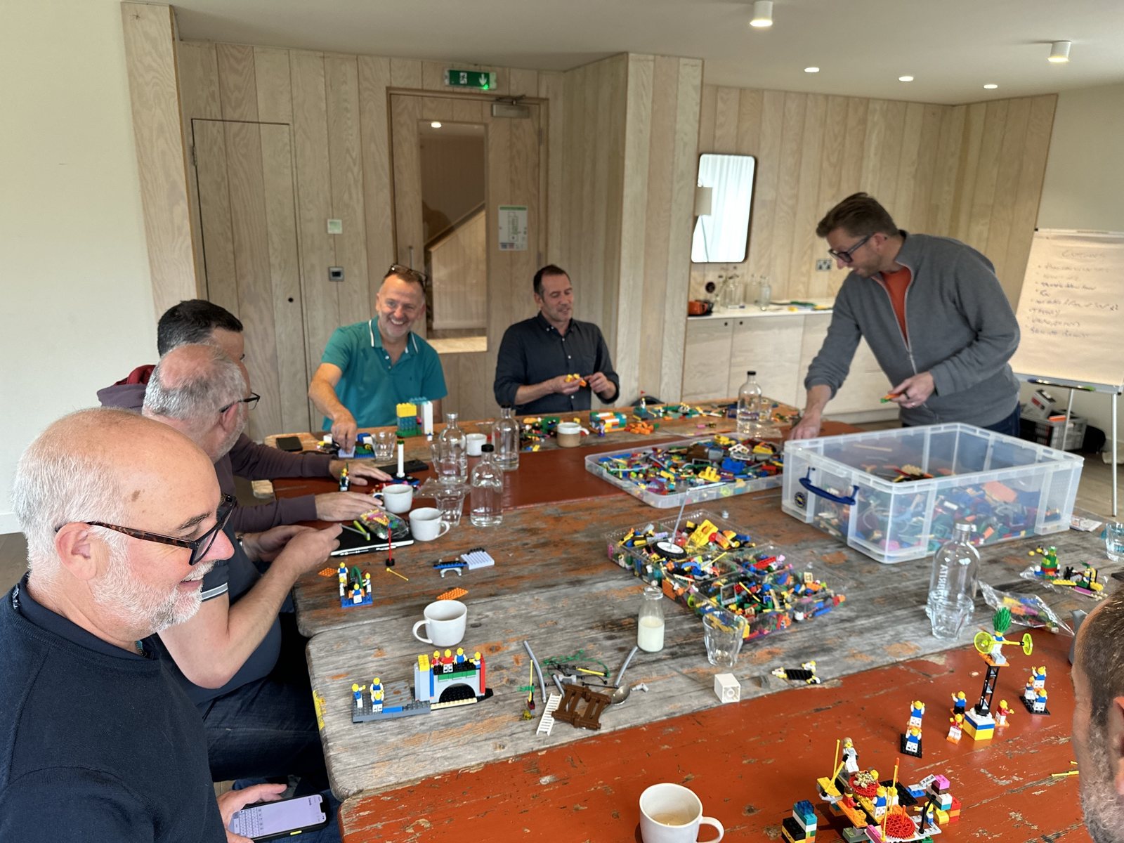 Leaders laughing together around the table during a LEGO SERIOUS PLAY workshop